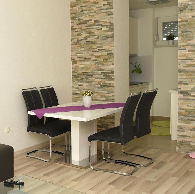 扎普雷希奇Angelina Apartment的一间用餐室,配有一张紫色的桌子和椅子