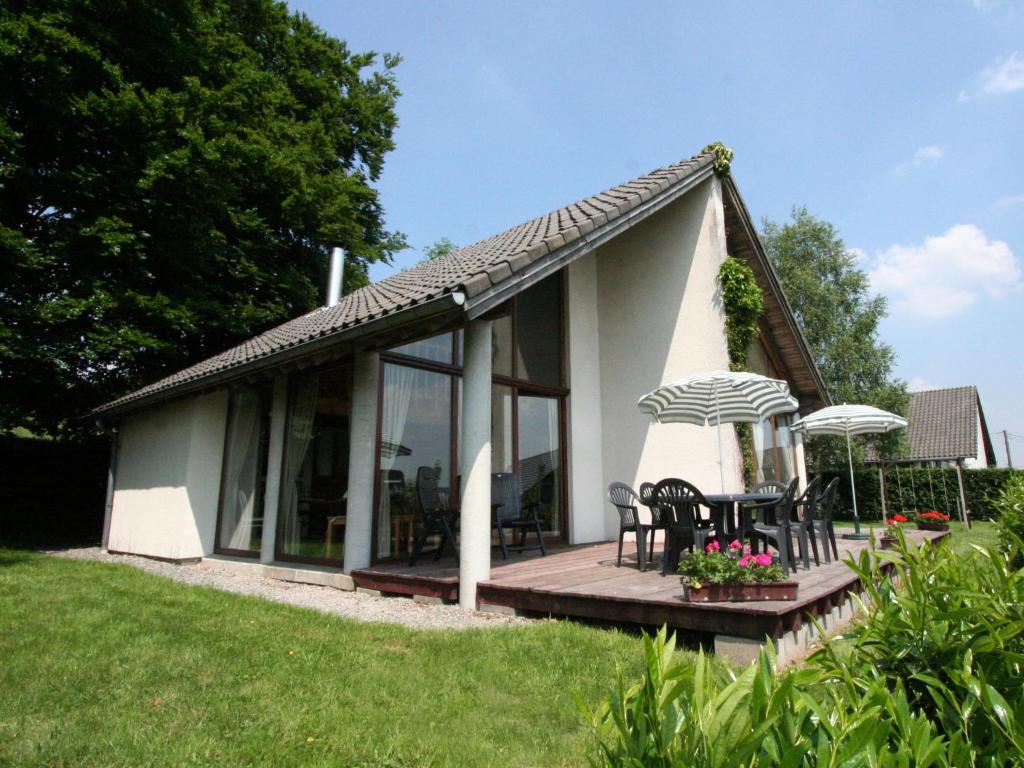 马尔梅迪this cottage is a superb chalet的白色的小小屋设有甲板和椅子