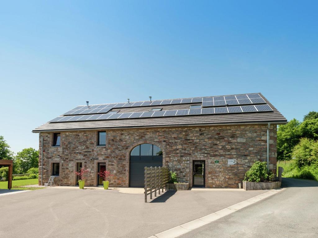 韦姆Heritage Holiday Home in Ovifat with Sauna的一座建筑,上面有很多太阳能电池板