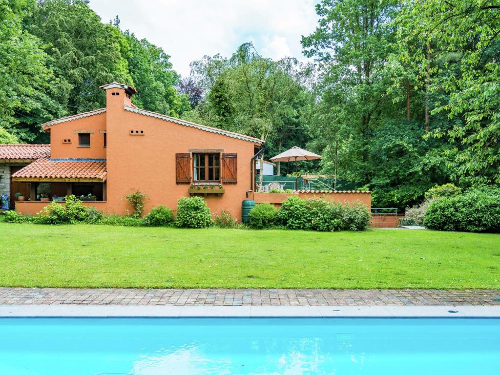 Zichemsveld斯特洛克博森酒店的房屋前方设有游泳池的庭院