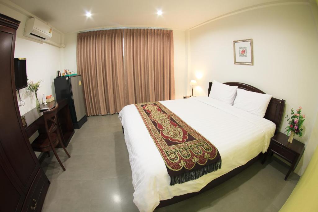 曼谷苏22号公寓的酒店客房设有一张大床和一张书桌。