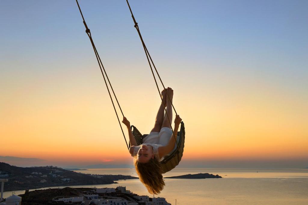 米克诺斯城麦肯尼亚奈亚 - 首选酒店及度假村 的女孩在日落时分悬在绳索摆架上