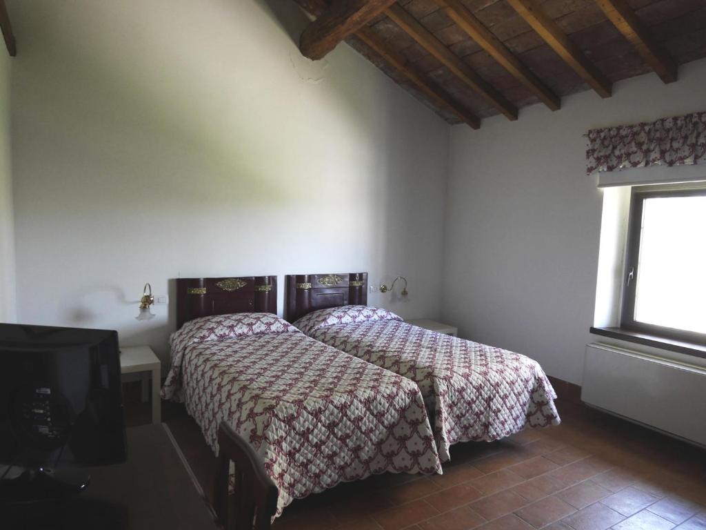 San Colombano al LambroAgriturismo San Bruno的一间卧室设有两张床和窗户。