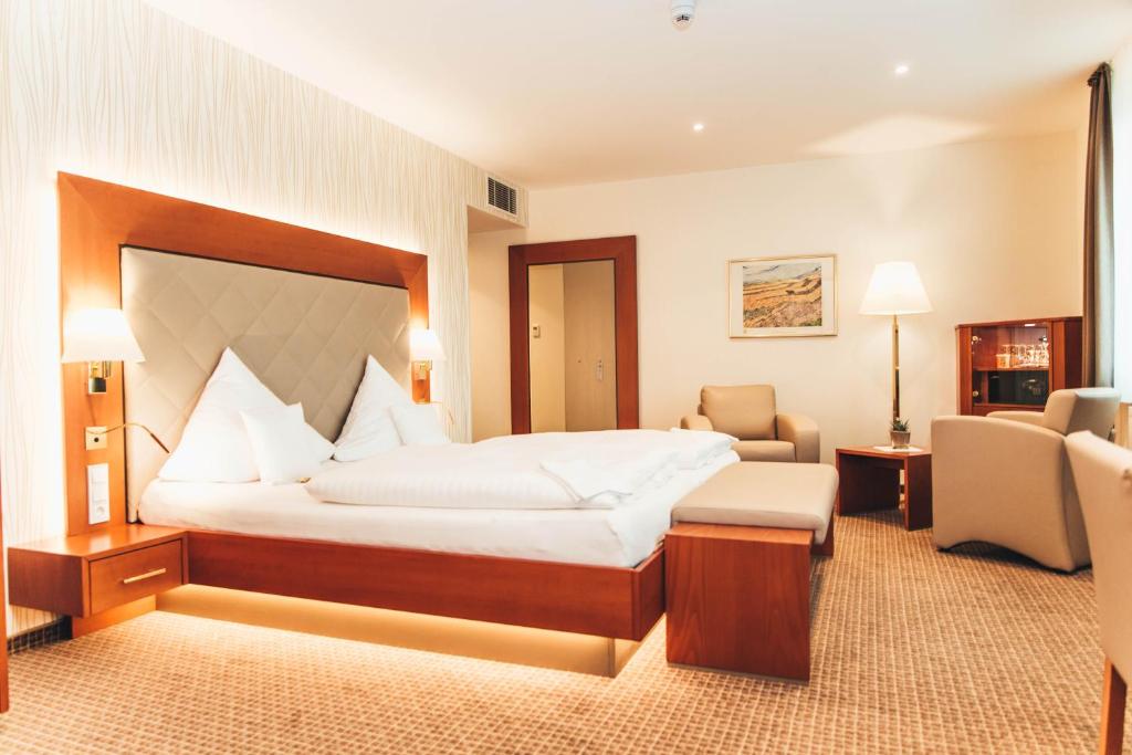 泰克伦堡图托贝格沃尔德环形酒店的酒店客房带一张大床和椅子