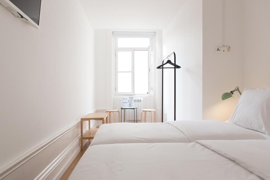 波尔图Porto Republica Riverside的白色卧室配有两张床和一张桌子