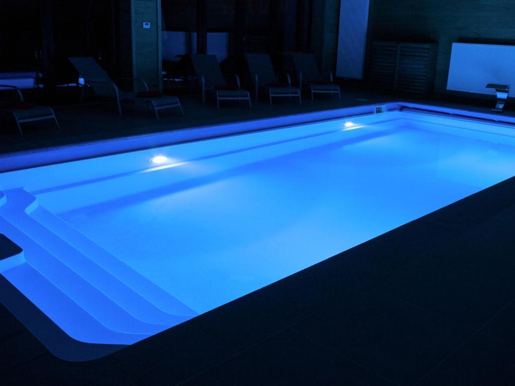 罗伯特维尔Luscious Holiday Home in Waimes with Pool Sauna的室内的蓝色灯光游泳池