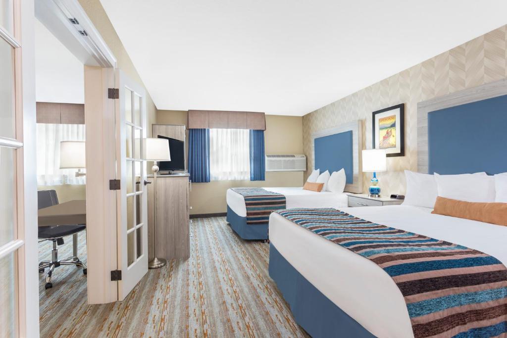 斯波坎谷SilverStone Inn & Suites Spokane Valley的酒店客房配有两张床和一张书桌