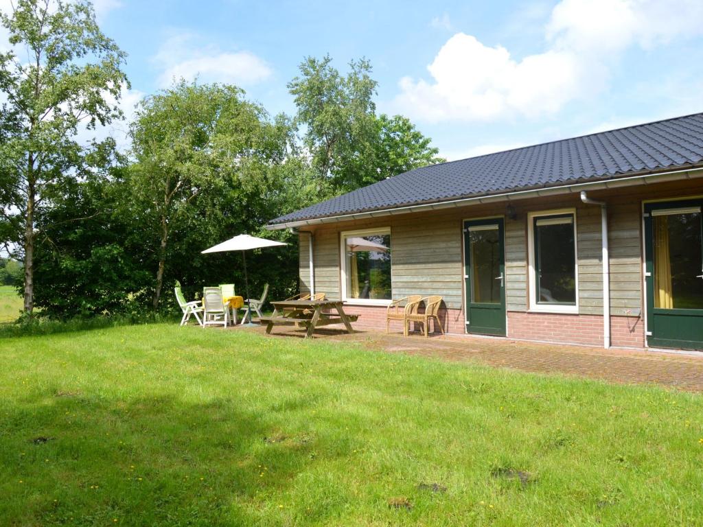 KibbelveenHoliday home with view over the meadows的房屋设有野餐桌和庭院