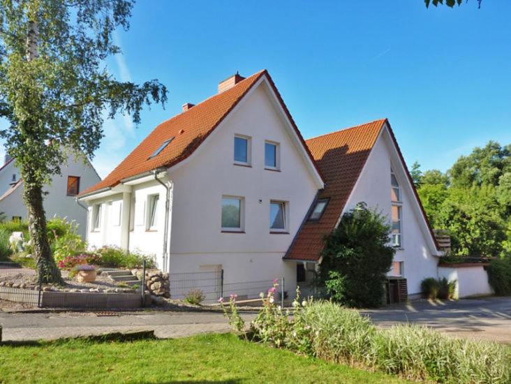 布隆Ferienwohnung Am Schwanensee的白色房子,有橙色屋顶