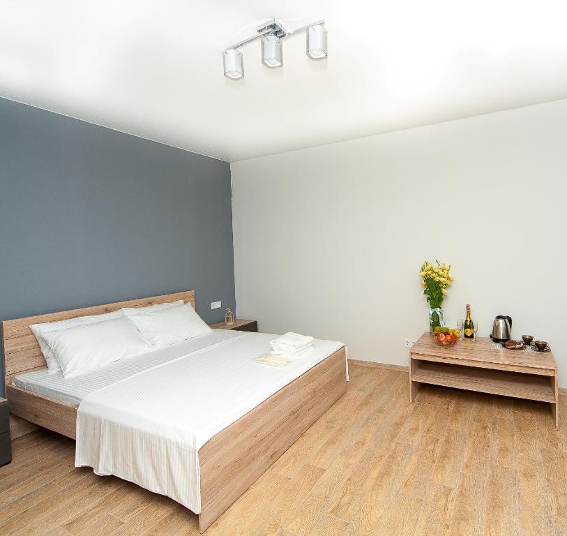 敖德萨Hotel Fusion的卧室配有白色的床和蓝色的墙壁