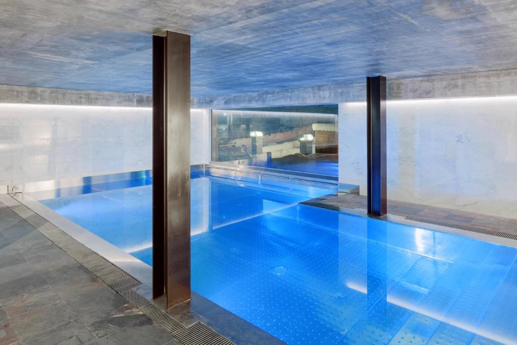 布勒伊-切尔维尼亚Aux Pieds du Roi - Suite & Spa的大楼内一个蓝色的大型游泳池