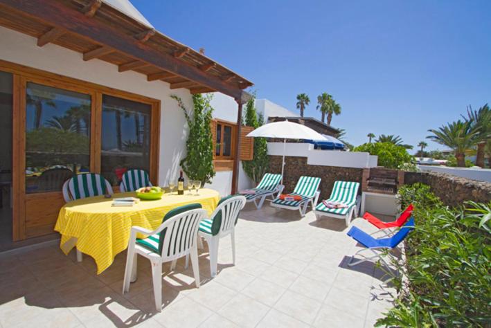 普拉亚布兰卡Playa Flamingo B的庭院配有桌椅和遮阳伞。