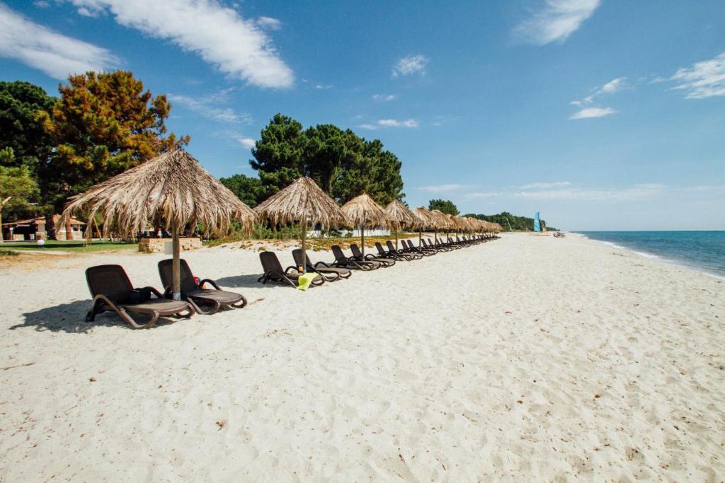 吉索纳恰维尼亚莱度假酒店的海滩上一排草伞和椅子