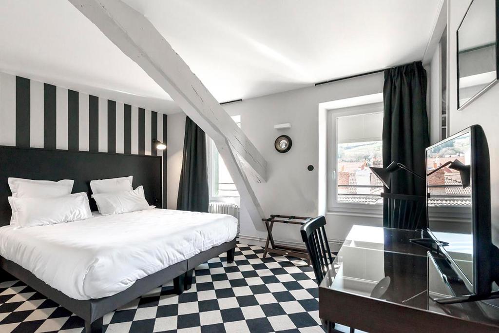 欧里亚克德斯卡默斯酒店的一间卧室配有一张床、一张桌子和一张玻璃桌