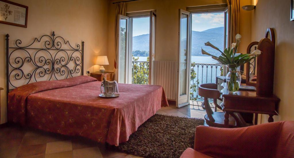 韦尔巴尼亚阿卡多斯酒店的一间卧室配有一张带桌子和窗户的床。