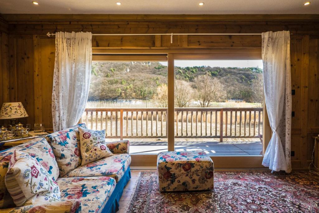 韦扎诺Maso Scricciolo Farm House的带沙发和大窗户的客厅