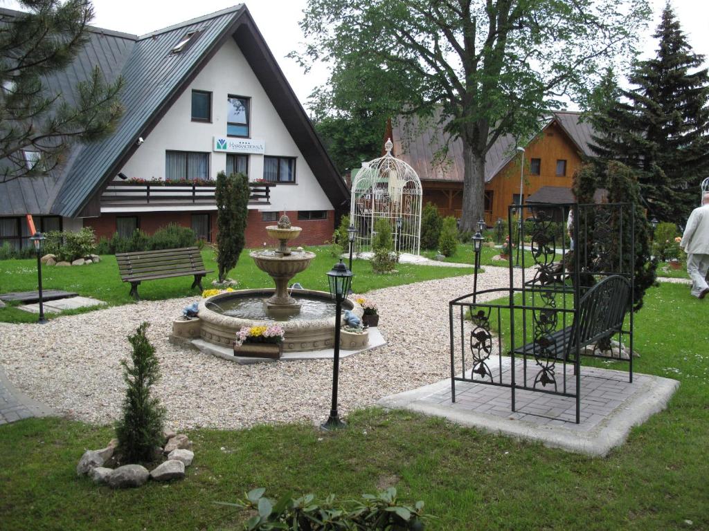 哈拉霍夫哈拉霍夫卡健康酒店的一座花园,房子前面有一个喷泉