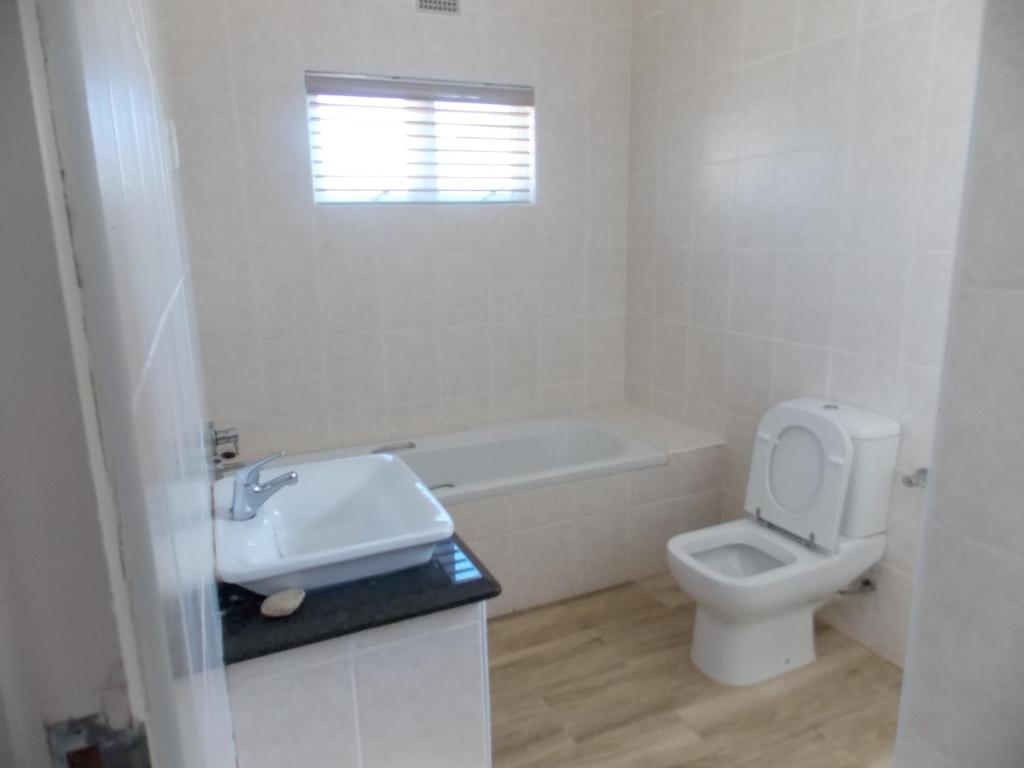 谢丽海滩Burd's Nest 215的白色的浴室设有水槽和卫生间。