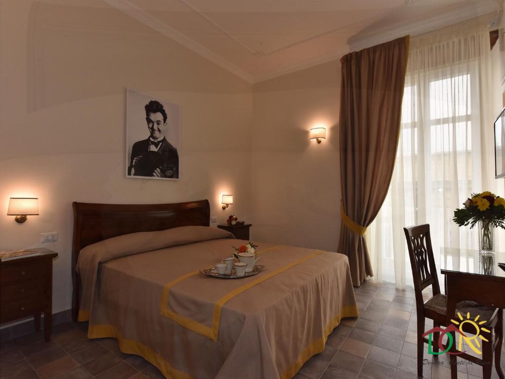 那不勒斯迪莫拉比迪鲁沃住宿加早餐旅馆的卧室配有一张带桌子的床,墙上挂着一张照片