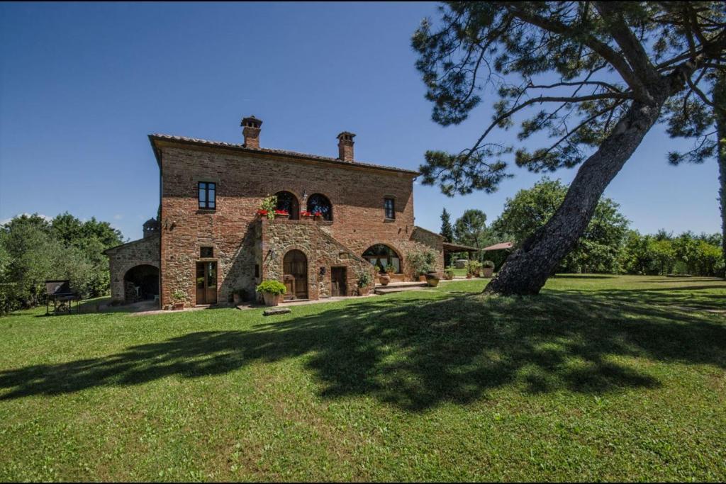 托里塔迪谢纳Villa Scianellone的一座大砖砌的建筑,院子里有一棵树