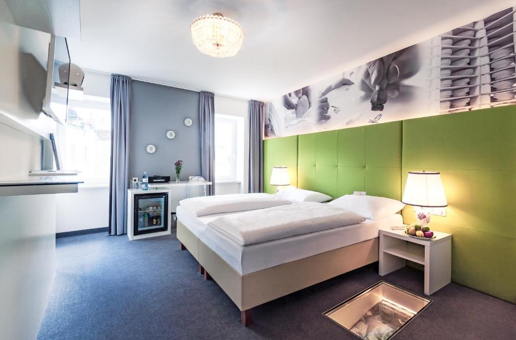 维也纳BoutiqueHOTEL Donauwalzer的一间卧室设有一张大床和绿色的墙壁