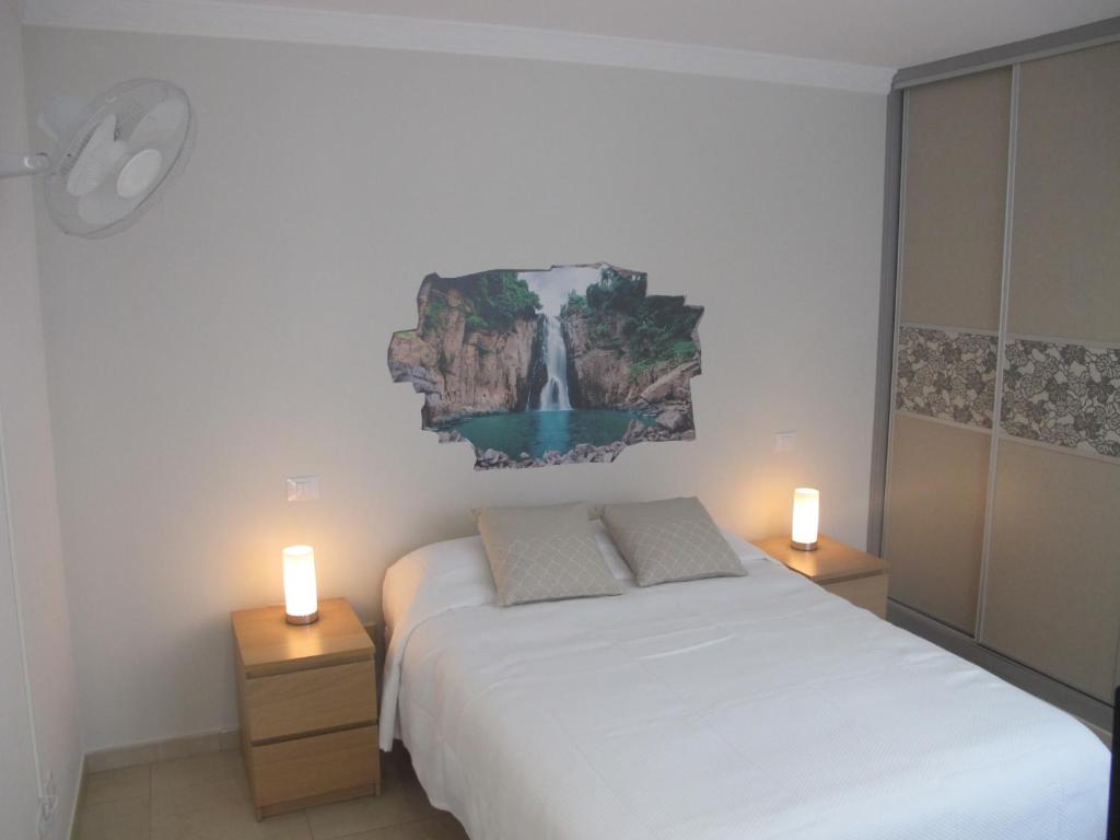 大加那利岛拉斯帕尔马斯Apartamento Kings Vegueta的一间卧室配有一张床,桌子上放着两把蜡烛