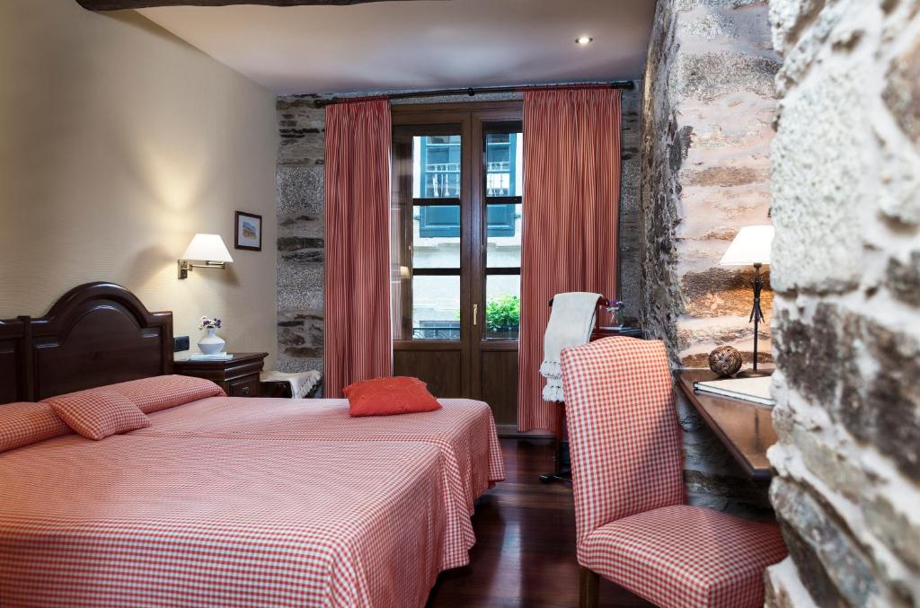 圣地亚哥－德孔波斯特拉比利亚尔街酒店的酒店客房设有两张床和窗户。