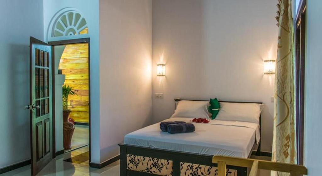 高尔阿里住宿加早餐旅馆的一间卧室配有一张床、镜子和门