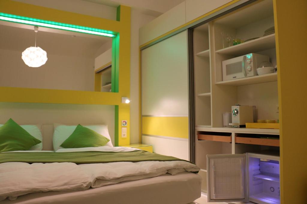 维也纳CH-Hotel Luka的一间卧室配有一张带绿色枕头的床
