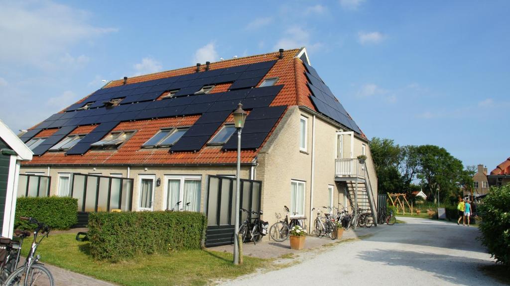 奥斯特仁德Appartementenhotel Tjermelân Terschelling的屋顶上设有太阳能电池板的房子