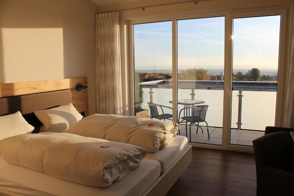 葡萄酒之路上的诺伊施塔特Gästehaus Rebenhof的一间卧室配有一张床,阳台配有桌子