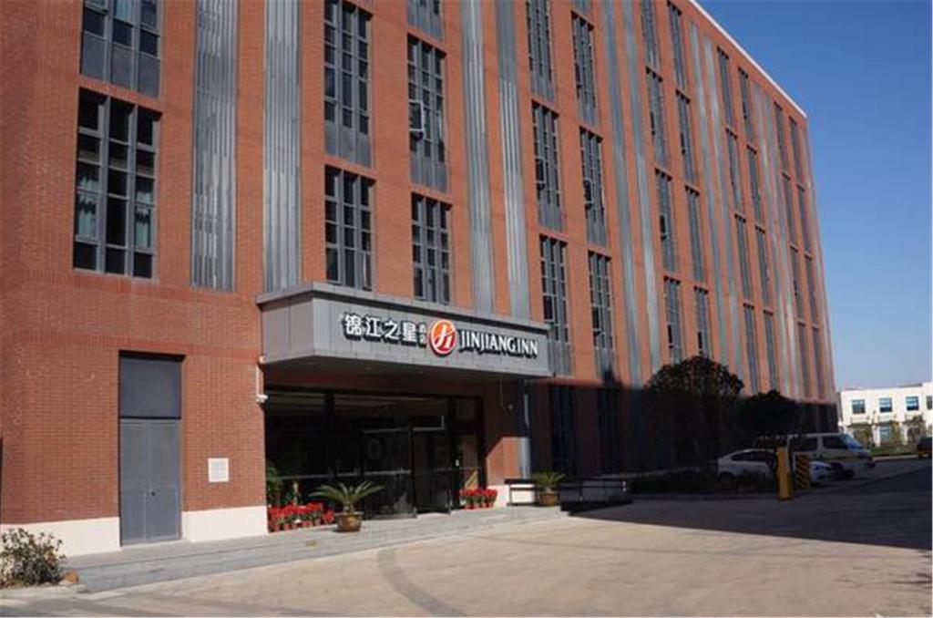 上海锦江之星品尚上海国际旅游度假区川沙地铁站酒店的一座大型红砖建筑,上面有标志
