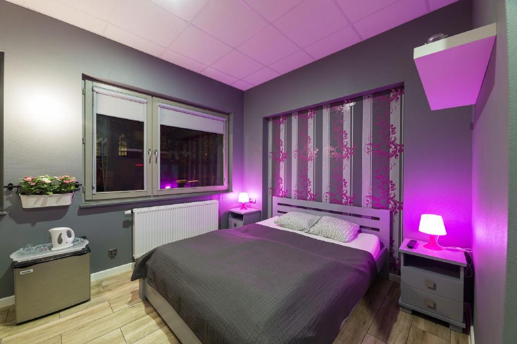 格但斯克菲利普2号旅馆的一间卧室设有紫色墙壁和一张带两盏灯的床
