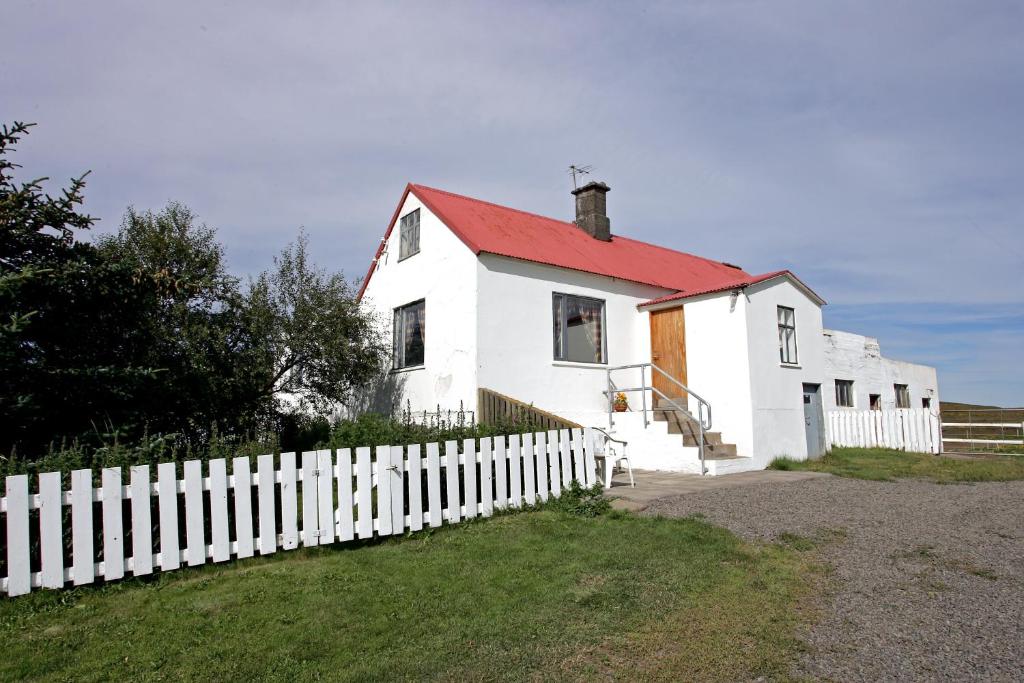 华姆斯唐吉apartment Neðra-Vatnshorn的白色的房子,有红色的屋顶和白色的围栏