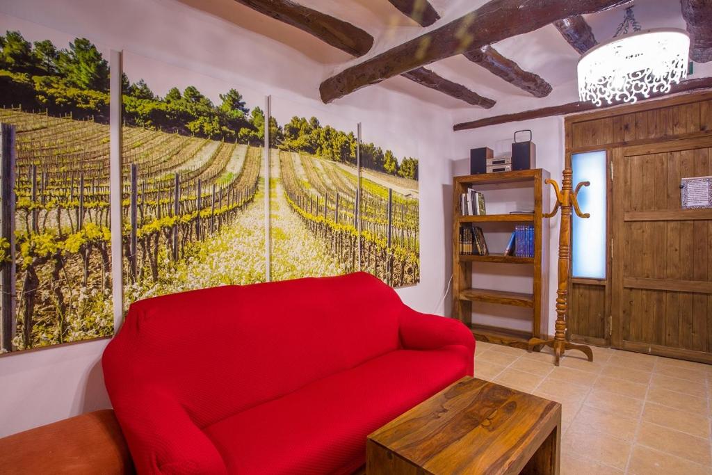 EnateB&B Casa Forcada的客厅配有红色沙发和绘画
