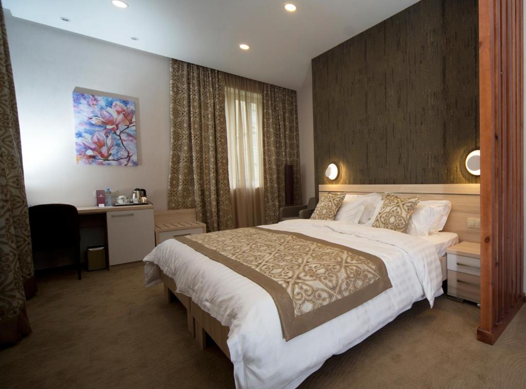 第比利斯伊比利亚迪杜贝酒店的一间卧室配有一张大床和一张书桌