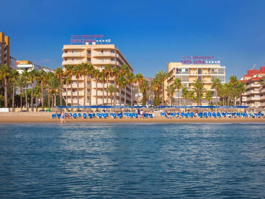 佩尼斯科拉瑟维集团帕帕卢纳酒店的海滩上,有椅子,棕榈树,建筑