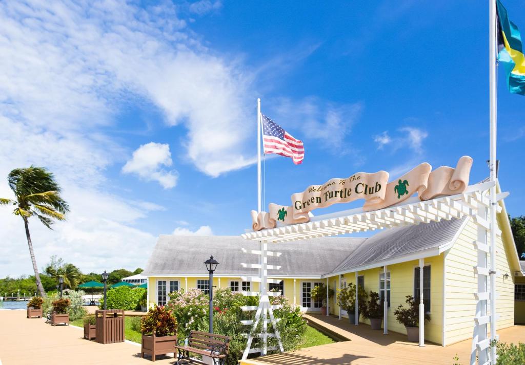 Green Turtle Cay绿海龟俱乐部滨海度假酒店的享有带美国国旗的海滩俱乐部前方的景致