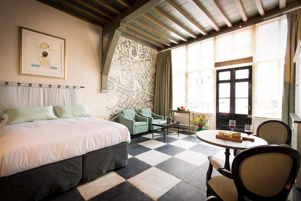 登博斯乌伦霍夫酒店的卧室配有一张床和一张桌子及椅子