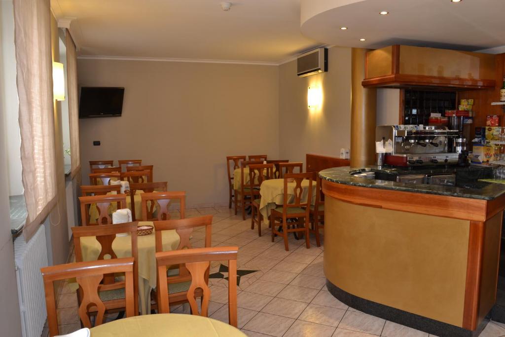 阿斯蒂Hotel Cavour的餐厅设有酒吧,配有桌椅