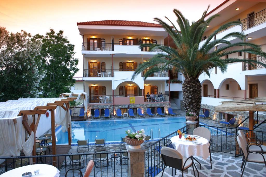 卡尼奥提卡利普索酒店的一座拥有游泳池和棕榈树的酒店