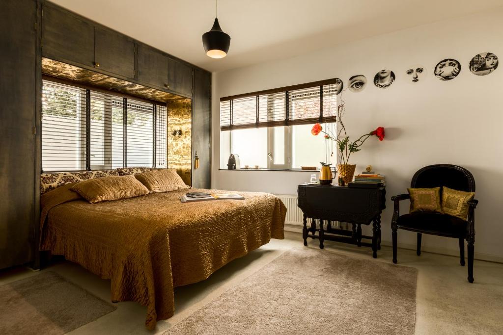 贝弗韦克B&B Habitat的卧室配有1张床、1张桌子和1把椅子