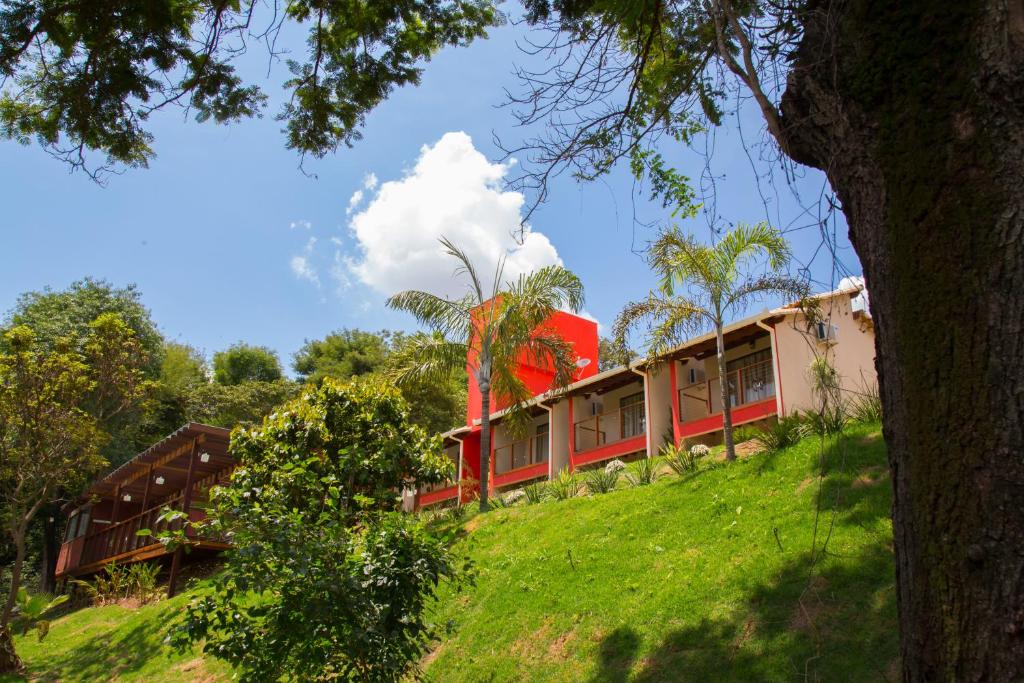布鲁马迪纽Pousada Verde Villas的绿色山顶上的红色建筑