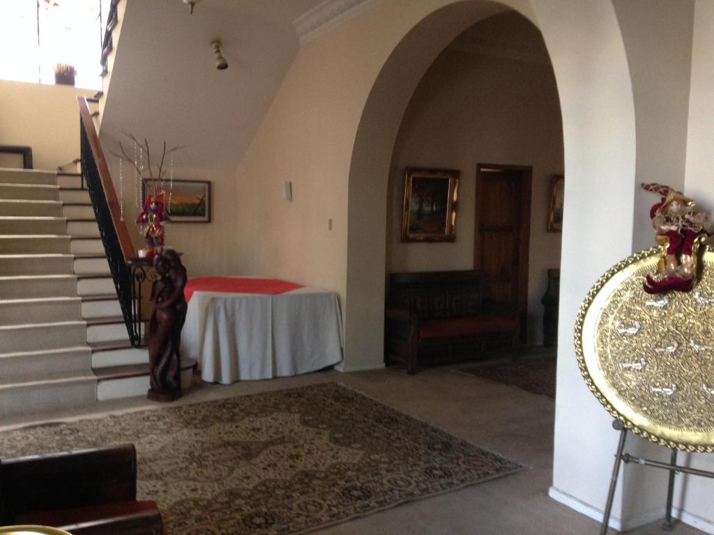 SangolquíMansion Samzara Hosteleria的走廊上设有桌子和楼梯,位于房子内