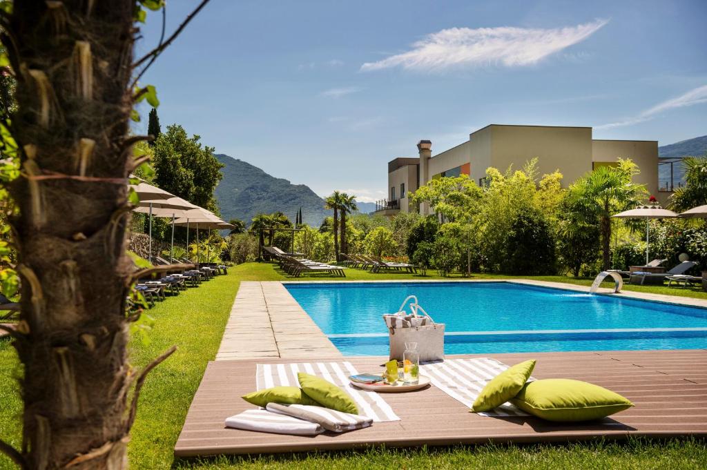 加尔达湖滨活动&家庭吉奥宜萨酒店的毗邻度假酒店的带桌子和枕头的游泳池
