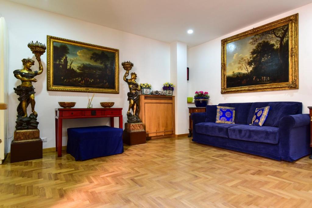 罗马Elite Rome Apartments的客厅配有蓝色沙发和绘画作品