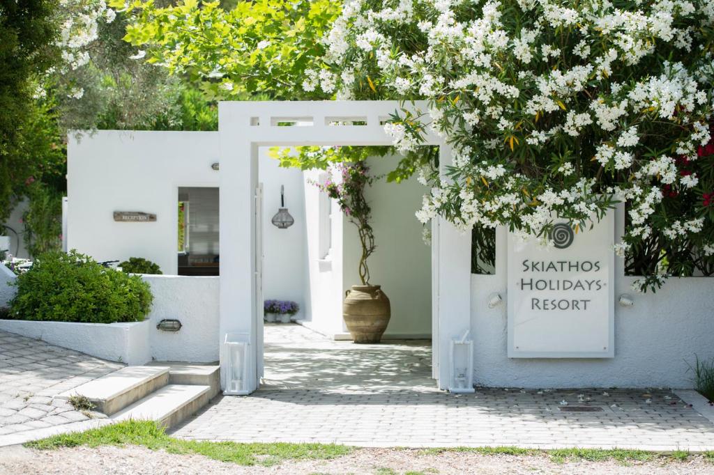 VromolimnosSkiathos Holidays Suites & Villas的白色的门,上面标有读santos haciendas resort的标志