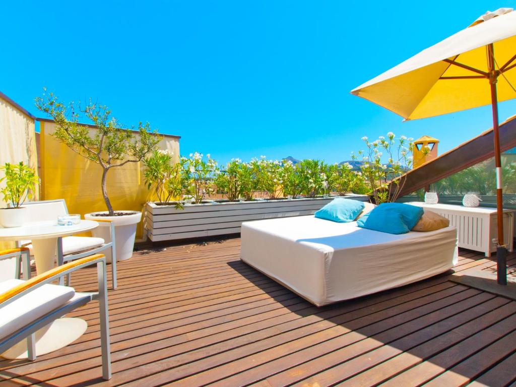 阿尔库迪亚卡斯费雷尔诺酒店的露台设有床铺和遮阳伞。
