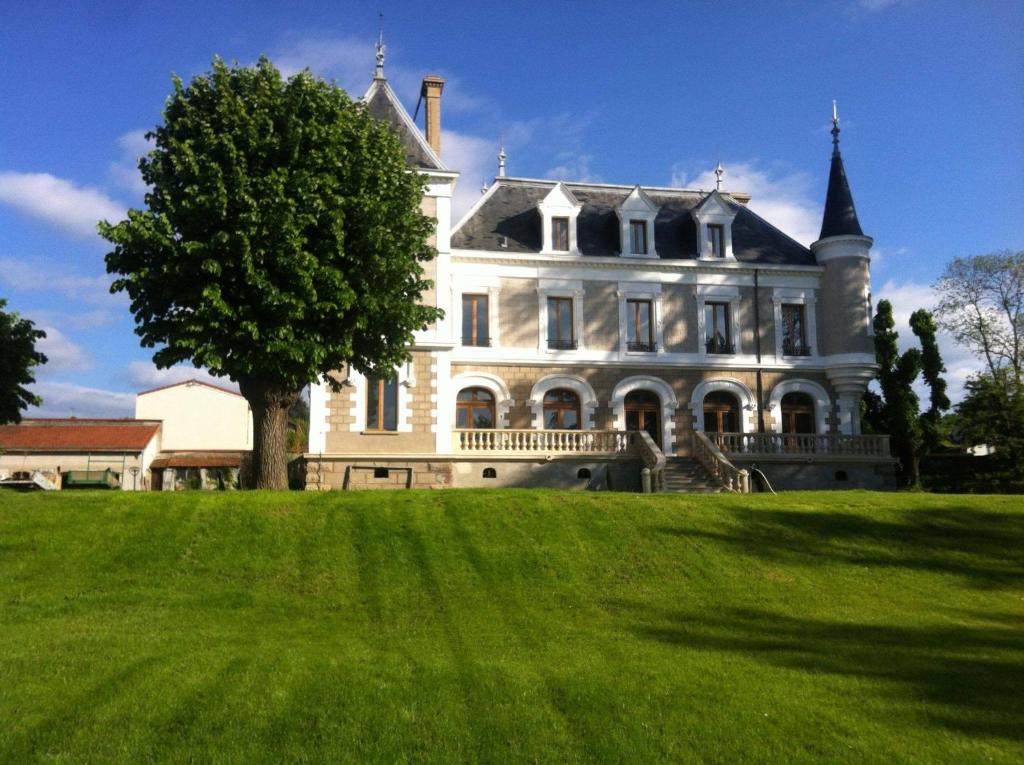 Saint-Paul-en-JarezEclosion Château Hôtel & Restaurant的前面有一棵树的大白色房子