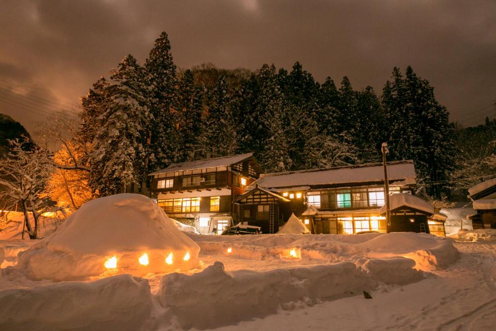 十日町濑户口旅馆的雪覆盖的房屋,晚上有灯